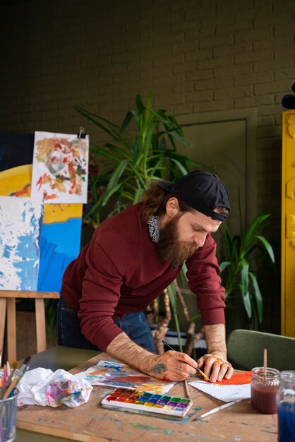 male painter using watercolor on his art in the studio