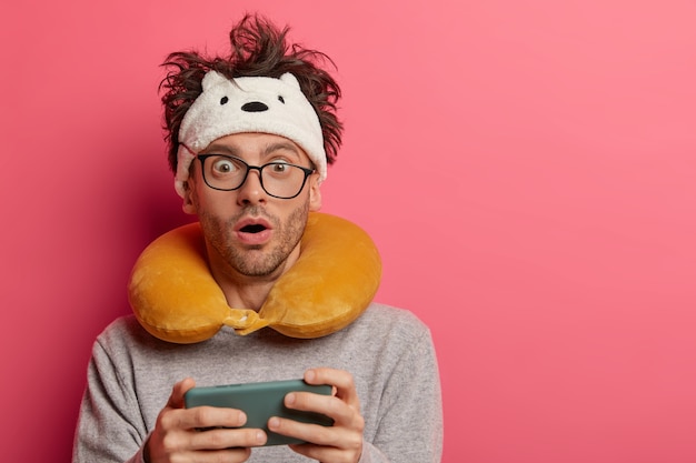 Free photo male passenger wearing inflated travel pillow over neck and cute eye mask