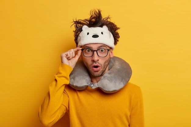 Male passenger wears travel pillow for sleeping during journey