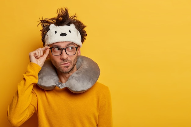 Male passenger wears travel pillow for sleeping during journey