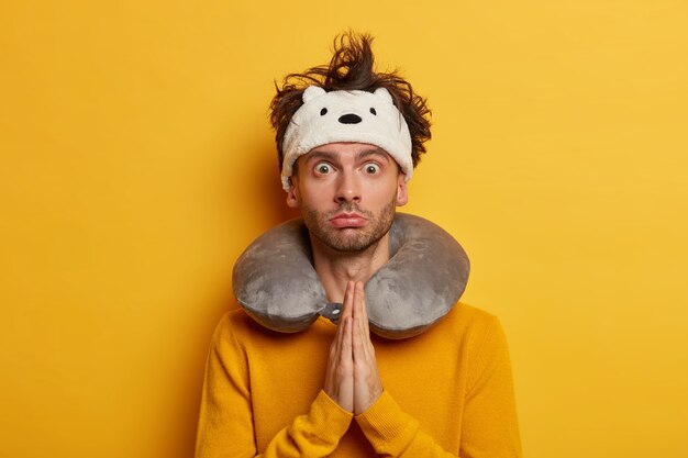 Male passenger wears travel pillow for sleeping during journey