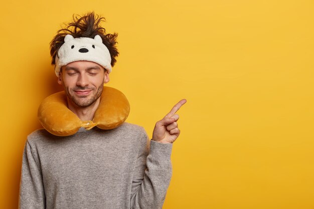 Male passenger wears travel pillow for sleeping during journey