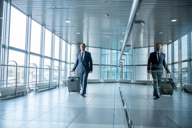 Male passenger with the baggage walking ahead