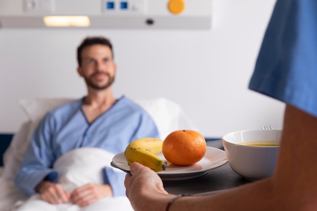 male patient in bed talking to a nurse