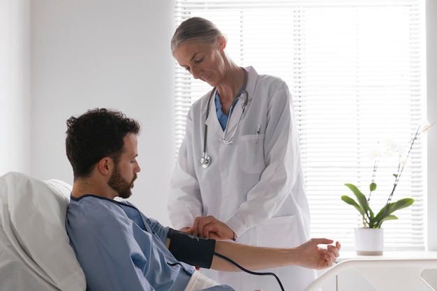 Male patient in bed talking to a nurse