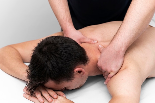Paziente di sesso maschile che riceve un massaggio alla schiena dal fisioterapista