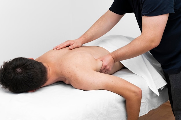 Free photo male patient being massaged by physiotherapist