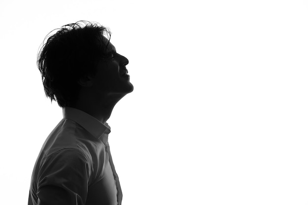 Male person silhouette in white clothing with excited face shadow white background