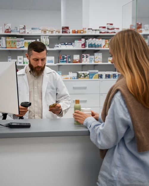 Farmacista maschio che consulta cliente femminile alla farmacia