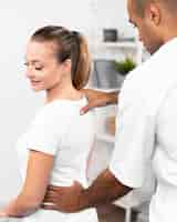 Free photo male physiotherapist checking woman's back pain