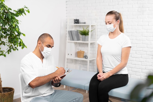 Free photo male physiotherapist checking woman