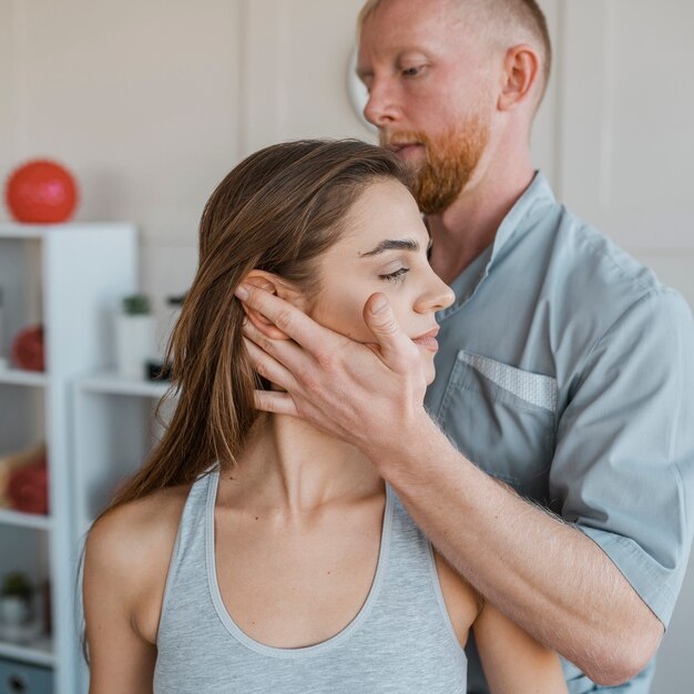 Male physiotherapist doing physical exercises with female patient