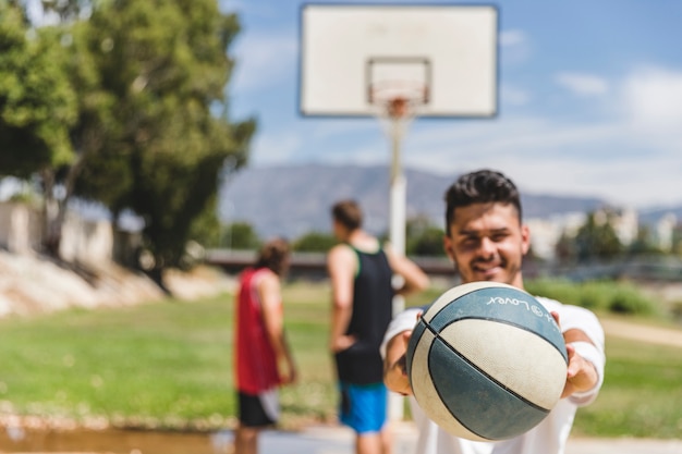 A male player holding basketball in front of camera