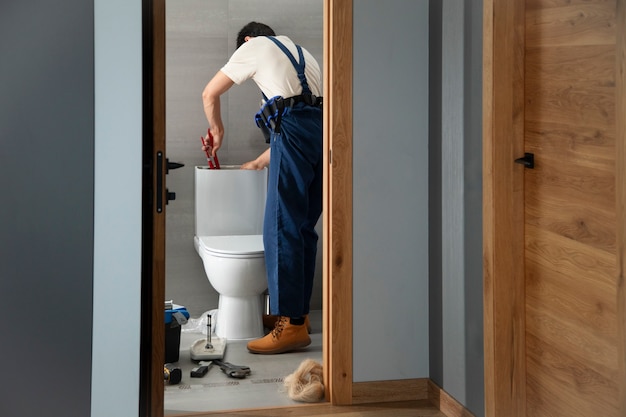 Un idraulico che lavora per risolvere problemi a casa di un cliente