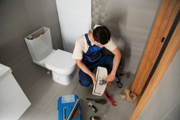 Foto gratuita un idraulico che lavora per risolvere problemi a casa di un cliente
