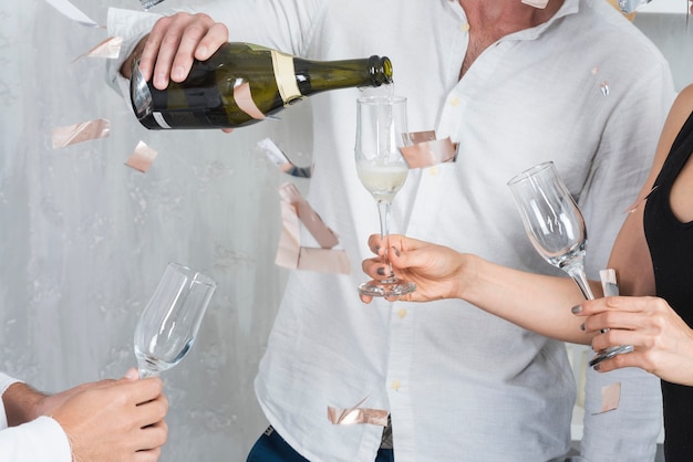 Free photo male pouring champagne in glasses