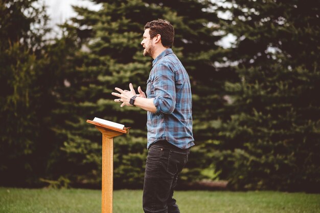A male reading the bible while standing near the podium