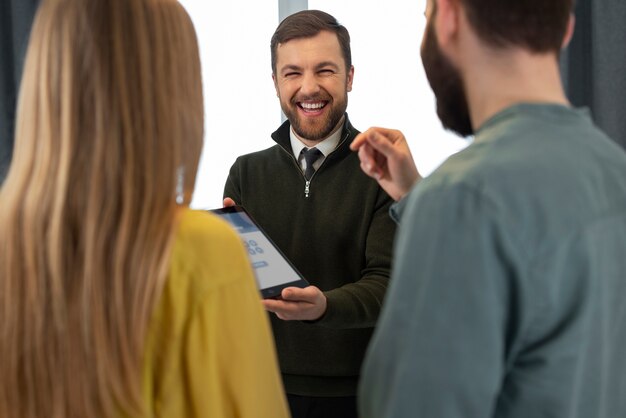 Male real estate agent doing business and showing house to potential buying couple