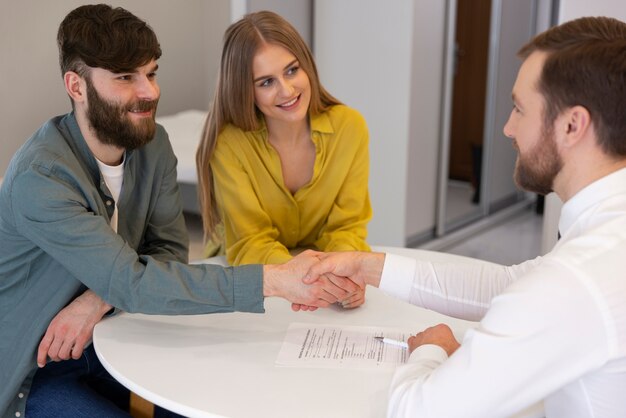 Male real estate agent doing business and showing house to potential buying couple