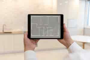 Free photo male real estate agent holding tablet with house plan