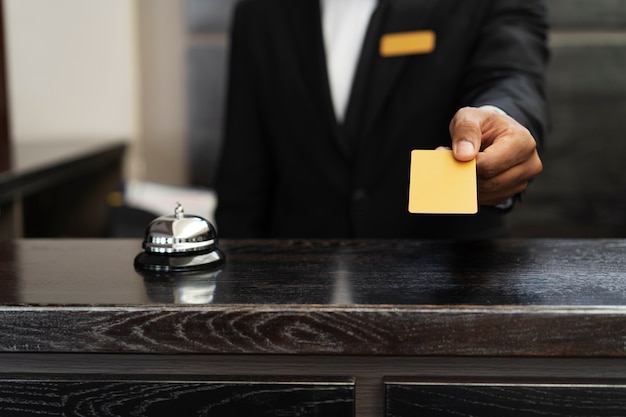 Free photo male receptionist in suit offering room key