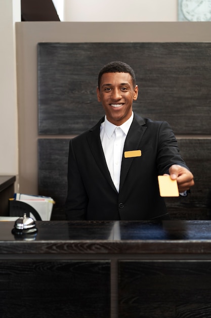 Male receptionist in suit offering room key