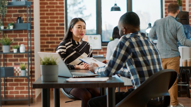 Male recruiter interviewing job seeker about work experience, making employment offer. Man and woman meeting to discuss about HR recruitment, analyzing resume information to hire.