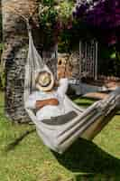 Free photo male relaxing in a hammock in the garden.