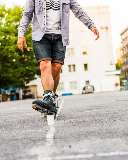 Male rollerskater's foot in front of disposal cup