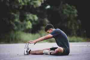 Free photo male runner doing stretching exercise, preparing for workout
