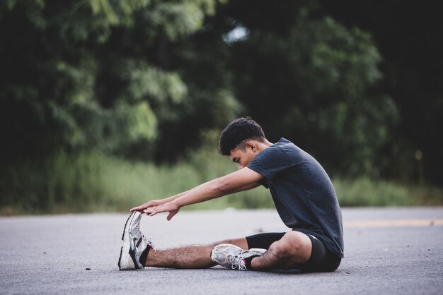 Male runner doing stretching exercise, preparing for workout