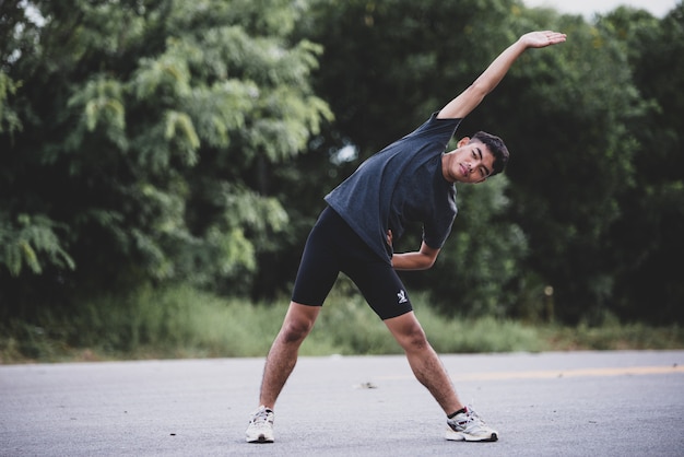 Corridore maschio facendo esercizio di stretching, preparando per allenamento