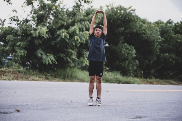 Male runner doing stretching exercise, preparing for workout