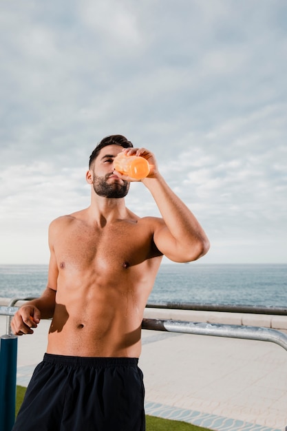 Male runner hydrating while break