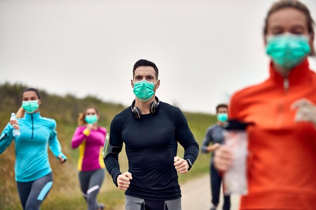바이러스 전염병 동안 마라톤 경주에 참가하는 동안 안면 마스크를 쓴 남성 주자