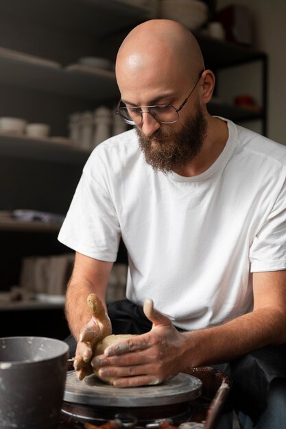 Male sculptor working with clay in the studio