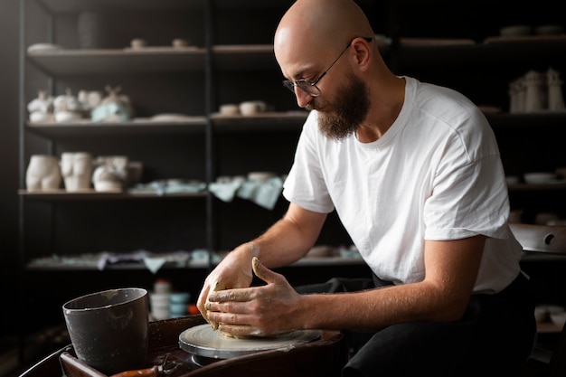 Male sculptor working with clay in the studio