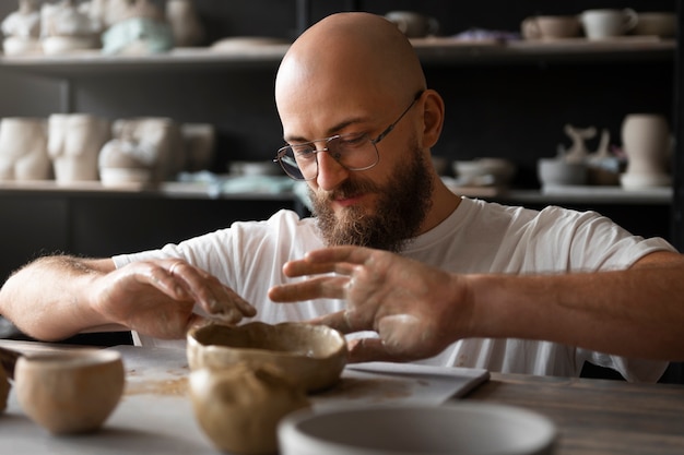 Male sculptor working with clay in the studio