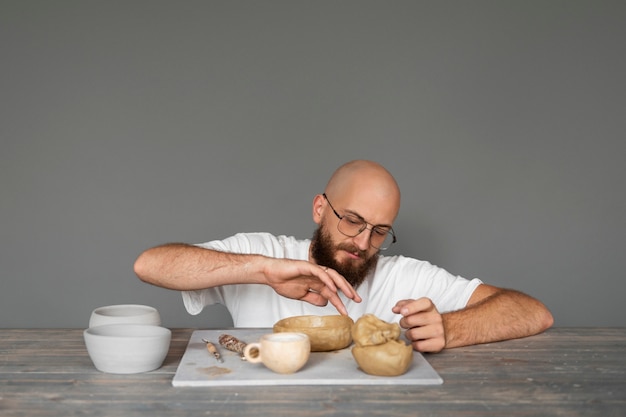 Free photo male sculptor working with clay in the studio