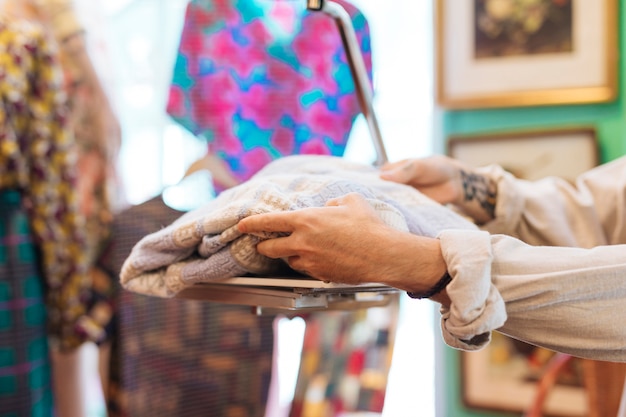 Male seller checking fabric weight on scales at clothing shop