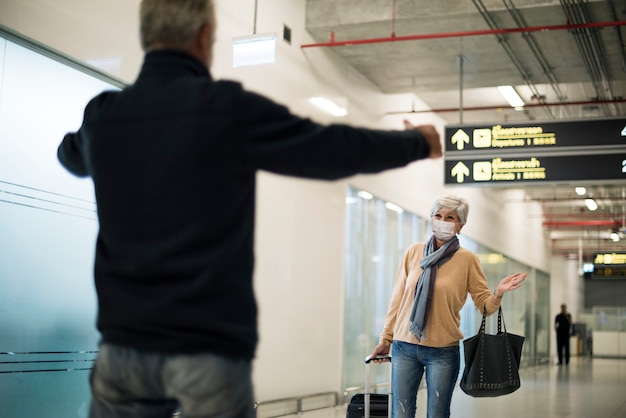 Male senior picking up his wife at the airport after covid-19 lockdown