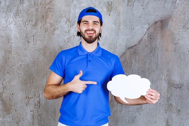 Male service agent in blue uniform holding a blank cloud shape info board