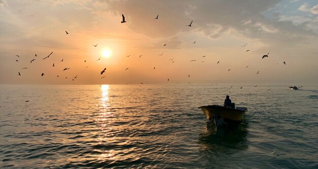 Мужчина в маленькой лодке посреди прекрасного моря с ярким солнцем