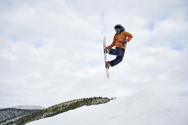 Мужчина-сноубордист делает трюки в воздухе на горнолыжном курорте