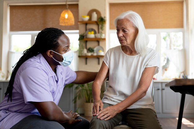 Free photo male social worker taking care of an old woman