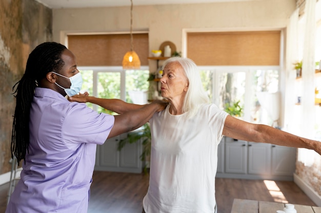 Free photo male social worker taking care of an old woman