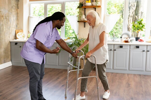 Male social worker taking care of an old woman