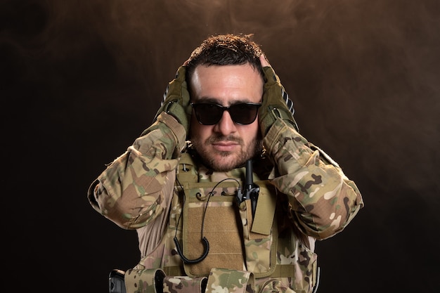 Free photo male soldier in camouflage on a dark wall