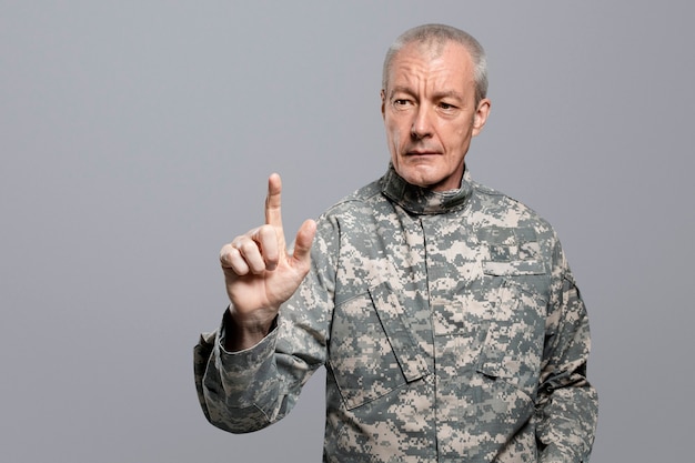 Male soldier pressing index finger on an invisible screen