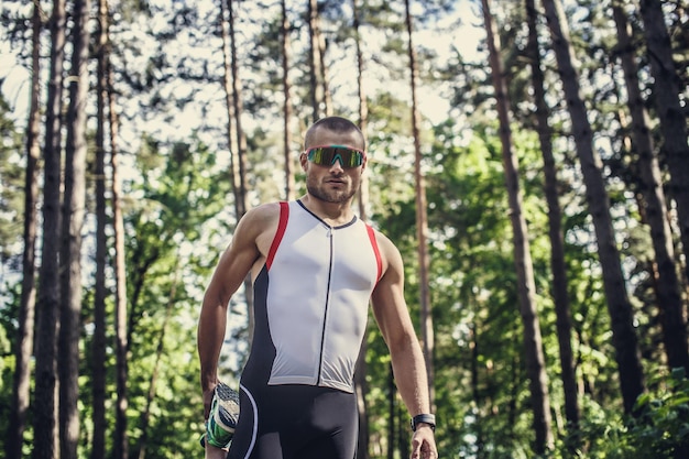Male in sportswear and sunglasses running in the forest.